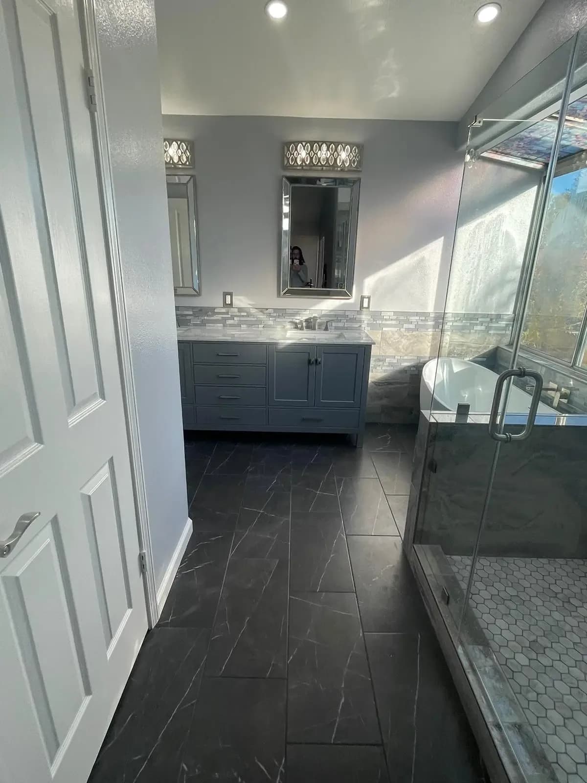 Bathroom with slate-grey tile, a double vanity and a glass shower